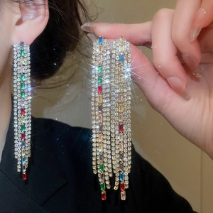 Macro shot of elegant long tassel earrings with vibrant colorful cubic zirconia stones