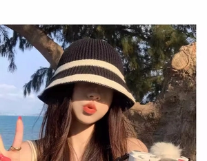 Detail view of striped knit bucket hat featuring soft texture and flexible sunshade brim