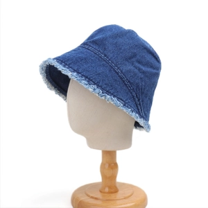 Detailed close-up of dark blue denim bucket hat featuring stylish frayed raw edges