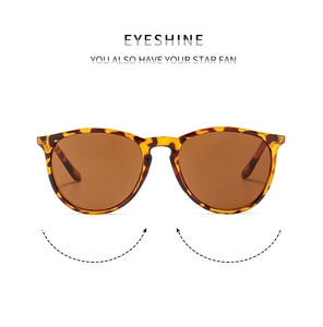 Detail of retro tortoiseshell round frame sunglasses with tinted lenses on white background