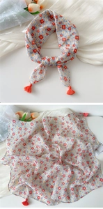 Close-up of cotton-linen floral scarf with orange tassels and light blue flower pattern