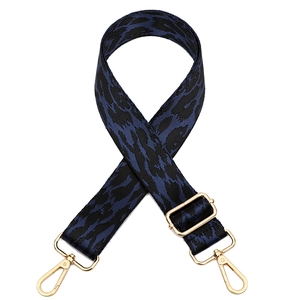Detail van de tasriem met luipaardprint in donkerblauw en zwart met gouden haken