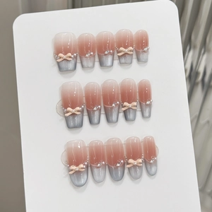 Detailed view of handmade pink cat eye press-on nails with 3D bows and pearls