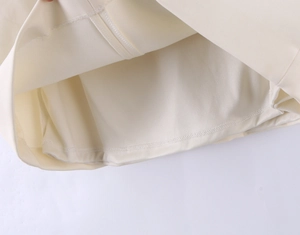 Gros plan de l'ourlet de robe blanc cassé avec coutures de qualité et doublure lisse