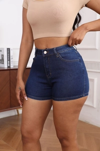 Detail shot of high-waisted dark blue denim shorts with a classic single-button closure