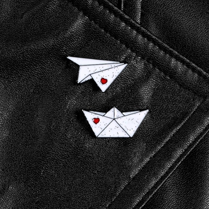 Minimalist white paper plane and boat enamel brooch set with red heart on black leather
