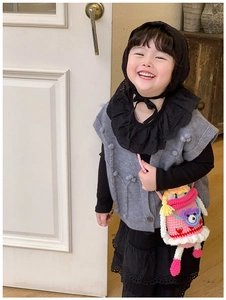 Bambina che indossa borsa a tracolla bambola in maglia rosa con orsetto e motivo fragola