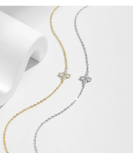 Detail of silver and gold four-leaf clover bracelets with sparkling cubic zirconia stones
