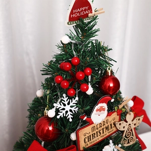 Mini tabletop Christmas tree with red baubles and berries for festive desk decoration
