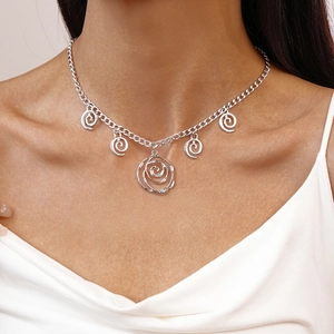 Close-up of silver necklace featuring six unique spiral pendants on a fine metal chain