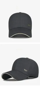 Detail view of grey twill baseball cap with golden sports metal tag and sandwich brim