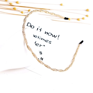 Close-up of golden thin twisted metal headband with protective black end caps