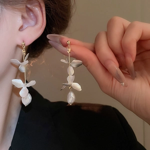Detail of floral petal drop earrings with long gold chain and baroque pearl tassel