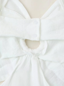 Gros plan du dos évidé blanc avec fermeture à bouton et texture en tissu de lin