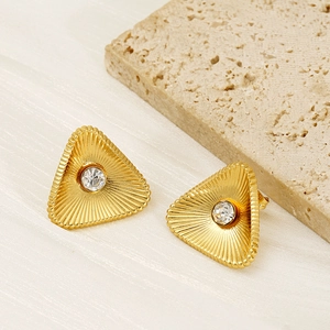 Golden titanium steel triangle stud earrings with center zircon on a beige stone