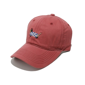 Detail of red cotton baseball cap featuring embroidered cartoon dachshund dog pattern