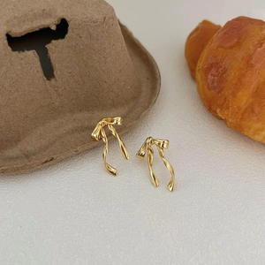 Minimalist gold ribbon bow earrings with a polished metallic finish in a French style