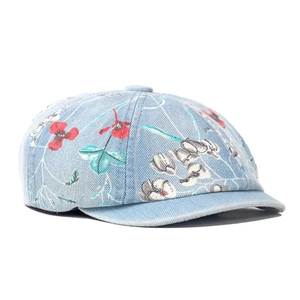 Detailed texture of denim beret featuring vintage floral print and premium stitching