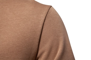 Detailed view of stitching and knit texture on the shoulder of a brown crewneck sweatshirt