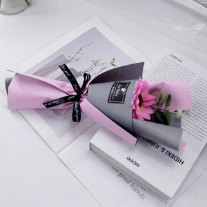 Detail view of pink gerbera bouquet with eucalyptus in elegant two-tone matte wrapping