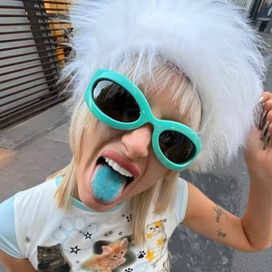 Detail of mint green Y2K oval sunglasses worn in a stylized urban streetwear setting
