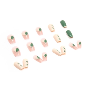 Pink and green ballerina press-on nails with heart patterns and solid dark green finish
