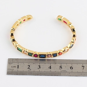 Golden open cuff bracelet with colorful geometric zircons and size measurement scale
