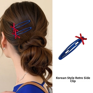 Detail of blue BB hair clip featuring a red bow accent on a Korean style hairstyle