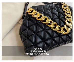 Detail of black quilted shell bag featuring thick gold chain strap and smooth texture
