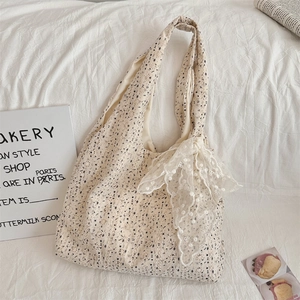 Detailed close-up of beige floral lace tote bag with a large decorative bow
