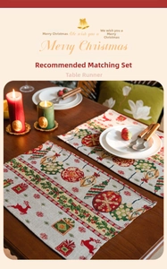 Close-up of woven Christmas placemats with reindeer and ornaments on a wooden table