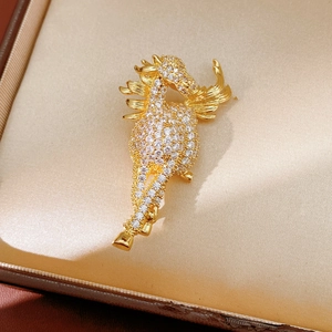 Detailed close-up of a gold-plated dragon brooch encrusted with white cubic zirconia stones