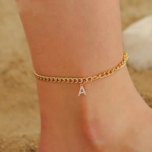 Cuban link anklet with crystal letter A pendant on woman ankle at beach