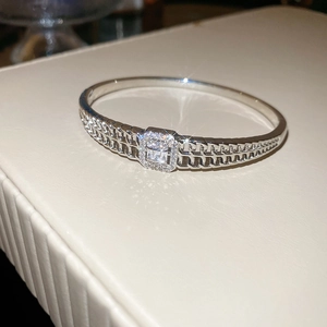 Gros plan d'un bracelet argenté avec chaîne ajourée à double rangée et zircons sertis