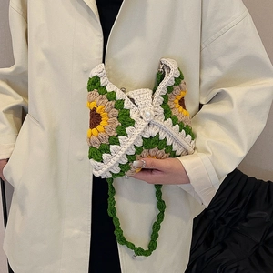 Handmade crochet sunflower shoulder bag with pearl clasp on model in trench coat