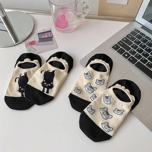 Detail of no-show socks featuring cute cartoon cat prints on a minimalist white desk
