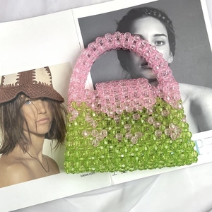 Detailed top view of a handmade pink and green beaded handbag on a fashion magazine