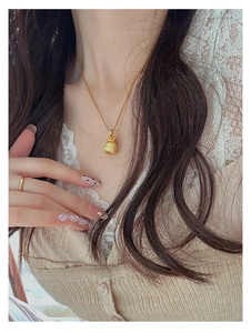 Detail der Gold-Glücksbeutel-Halskette und des minimalistischen Rings am Modell