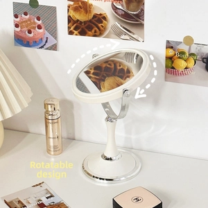 Detail of vintage beige desktop makeup mirror with swivel frame on a dressing table