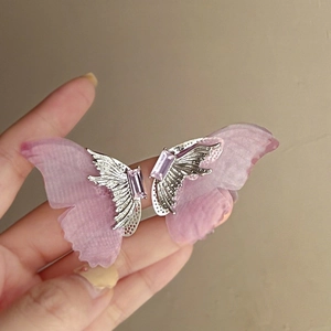 Vue détaillée de boucles d'oreilles papillon avec pierres mauves et ailes en tulle