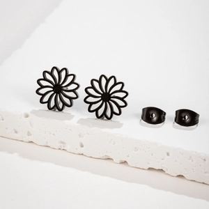 Minimalist black daisy hollow stainless steel earrings on white stone surface