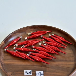 Macro view of 9cm red shiny teardrop Christmas ornaments with silver caps in a wooden bowl