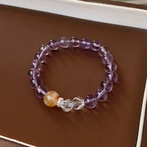 Detail of fluorite and zircon beaded bracelet with natural crystals on a leather stand
