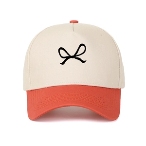 Detailed close-up of bow embroidery on two-tone cotton canvas trucker baseball cap