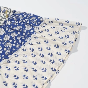 Close-up of patchwork floral dress fabric with navy blue and cream bird prints