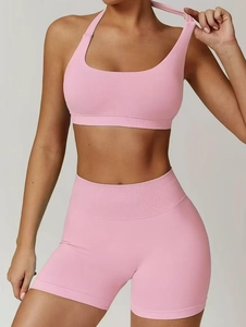 Close-up of pink seamless ribbed fabric on halter neck yoga bra and high waist shorts