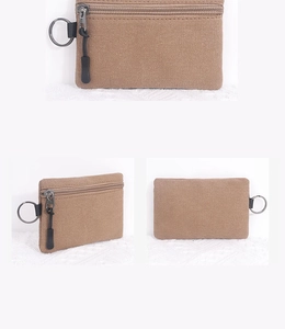 Close-up of canvas mini wallet showing woven texture, zipper, and metal keychain ring