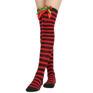 Detail of red and black striped over-the-knee Christmas socks with a decorative bow