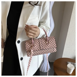 Pink monogram crossbody bag with retro geometric pattern and metal clasp in lifestyle view