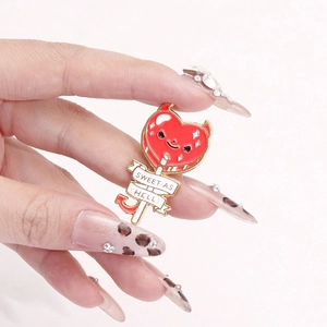 Creative devil heart lollipop enamel pin with Sweet As Hell text and golden metal edges